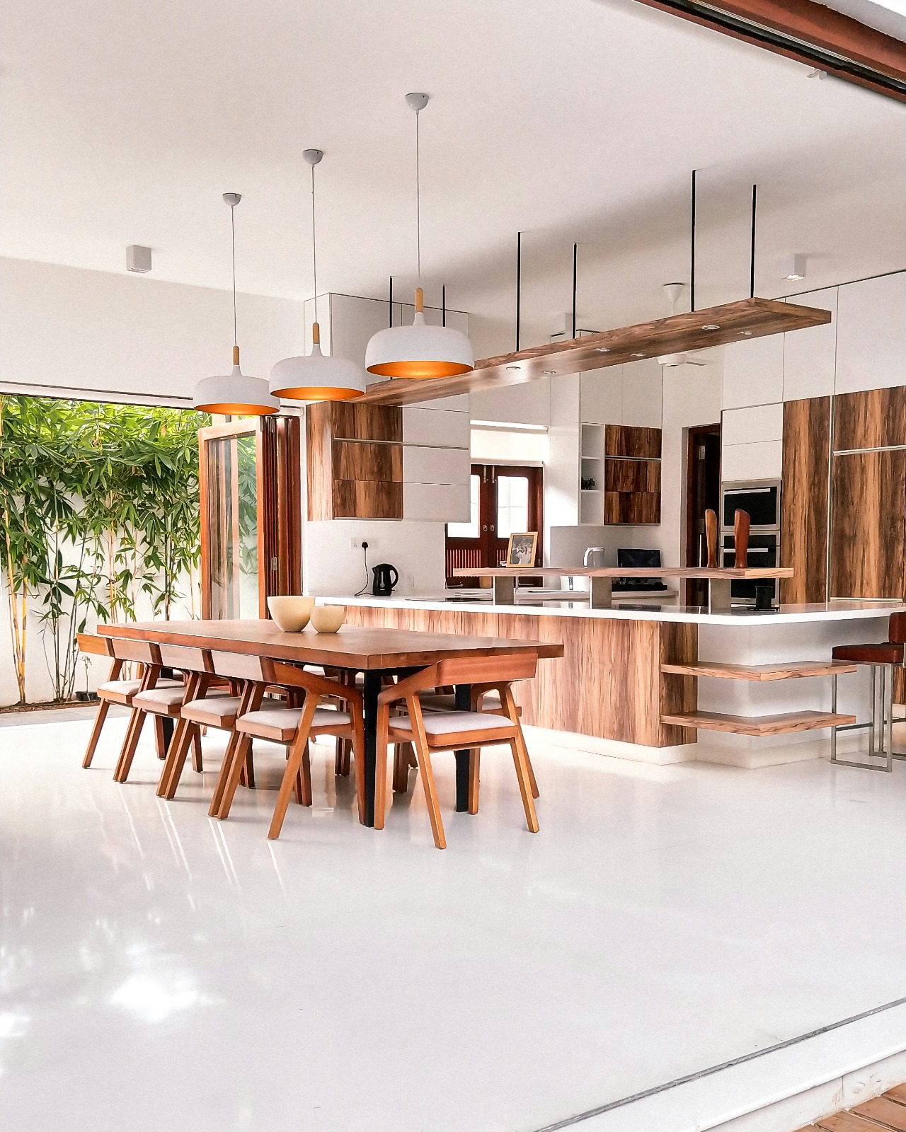 Modular kitchen with wooden cabinetry and built-in oven by Viona Interiors